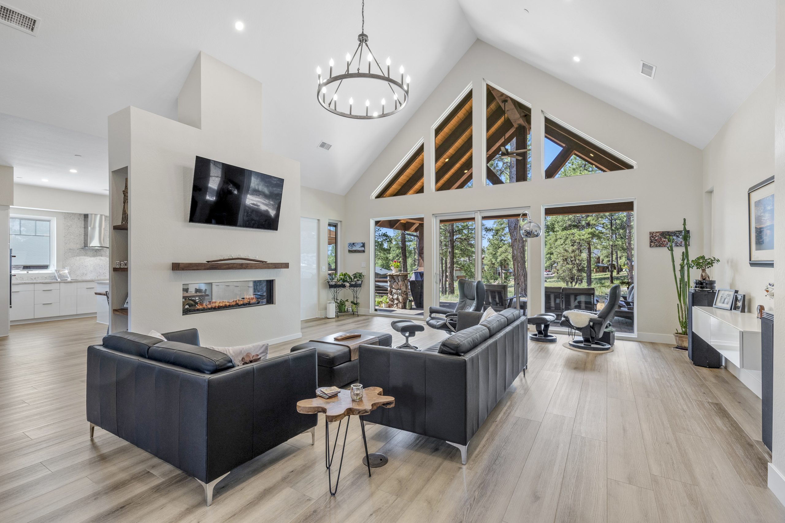 beautiful custom home with high ceilings with big beautiful windows, a two sided fireplace, mantle and large television